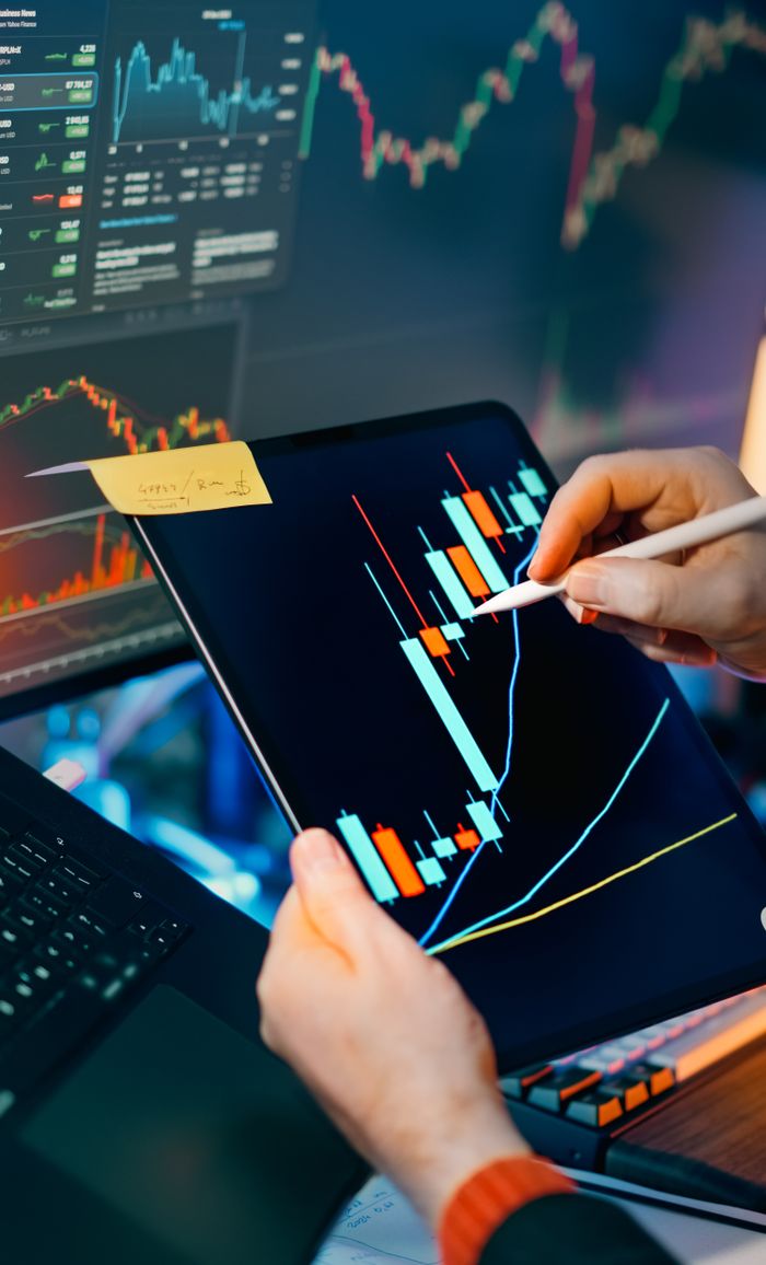 About Person using a tablet to analyze financial charts for trading insights. Perfect for finance and technology themes.