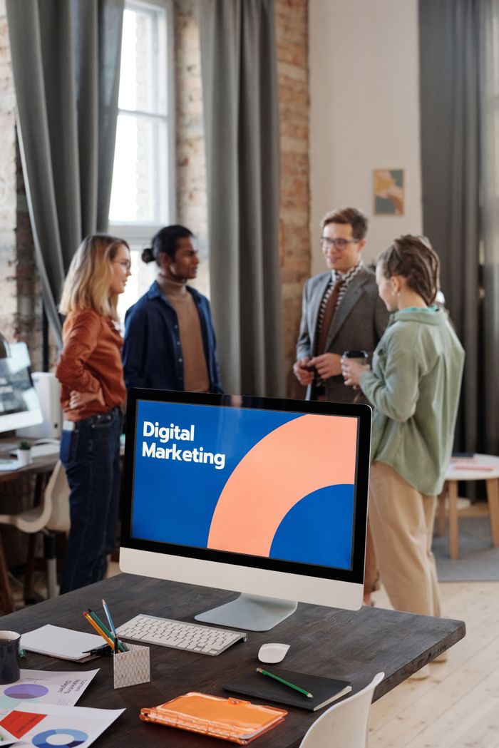 Portfolio Business team engaged in a digital marketing discussion in a modern office setting.