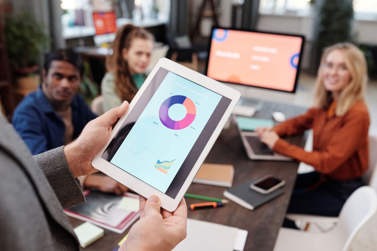 About Business team using a tablet to analyze digital marketing data with charts in an office setting.