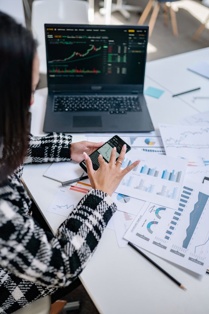 The Art of Drawing Readers In: Your attractive post title goes here Businesswoman evaluating stock market trends using graphs and smartphone in office.